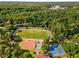 Aerial view features a sports field, baseball diamond, and tennis courts surrounded by trees at 1919 Edinburgh Ne Ter, Atlanta, GA 30307