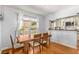 Sunlit dining area featuring hardwood floors, a view of the yard, and an open pass-through to the kitchen at 1919 Edinburgh Ne Ter, Atlanta, GA 30307