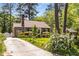 Charming brick home with a well-manicured lawn, flowering shrubs, and a classic brick chimney at 1919 Edinburgh Ne Ter, Atlanta, GA 30307