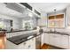 Open kitchen with granite countertops, white cabinets, subway tile, and a view into the living room at 1919 Edinburgh Ne Ter, Atlanta, GA 30307