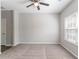 Spacious carpeted bedroom featuring a ceiling fan and large window, offering a comfortable retreat at 6757 Delaware Bnd, Fairburn, GA 30213