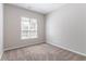 Neutral bedroom with plush carpet, bright window, and fresh paint, creating a serene atmosphere at 6757 Delaware Bnd, Fairburn, GA 30213