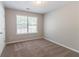 This carpeted bedroom has a window to let the sun shine in at 6757 Delaware Bnd, Fairburn, GA 30213