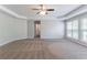 Spacious primary bedroom features a ceiling fan, tray ceilings, and large windows at 6757 Delaware Bnd, Fairburn, GA 30213