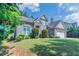 Beautiful single-Gathering home featuring lush green lawn, mature trees, and a well-maintained facade at 6757 Delaware Bnd, Fairburn, GA 30213