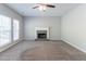 Bright living room showcasing a fireplace, a ceiling fan, and large windows for natural light at 6757 Delaware Bnd, Fairburn, GA 30213