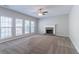Cozy living room featuring a fireplace, large windows, and a ceiling fan for comfortable living at 6757 Delaware Bnd, Fairburn, GA 30213