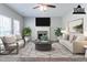 Bright living room with a cozy fireplace, neutral colors, and a modern ceiling fan at 6757 Delaware Bnd, Fairburn, GA 30213