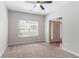 Bright, carpeted living area with a ceiling fan and entry view at 6757 Delaware Bnd, Fairburn, GA 30213