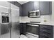 Kitchen with stainless steel appliances, dark cabinetry, quartz countertop and subway tile backsplash at 821 Ralph Mcgill Ne Blvd # 2412, Atlanta, GA 30306