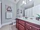 Bathroom showcases a wood vanity, white countertop, large mirror, and decorative wall art at 1076 Pinyan Ln, Canton, GA 30115