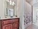 Bathroom boasts wood vanity with white countertop, decorative shower curtain and tile floors at 1076 Pinyan Ln, Canton, GA 30115