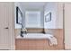Bright bathroom features a tile-surround soaking tub with dark fixtures and neutral decor at 1076 Pinyan Ln, Canton, GA 30115