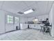 Spacious laundry room featuring white cabinets, modern appliances, tile flooring, and double doors to the outside at 1076 Pinyan Ln, Canton, GA 30115