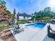 Inviting backyard pool with lounge chairs, patio furniture, and lush landscaping at 1076 Pinyan Ln, Canton, GA 30115