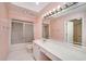 A bathroom with a shower, toilet, long counter, sink, and a large mirror with vanity lighting above the sink at 2009 Pine Forest Ct, Jonesboro, GA 30236