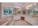 Elegant bathroom featuring a soaking tub, dual sinks, and a large vanity mirror at 2009 Pine Forest Ct, Jonesboro, GA 30236