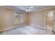 A bedroom with a carpet, a window overlooking a forest, a fan, and a closet just through the door to the right at 2009 Pine Forest Ct, Jonesboro, GA 30236
