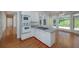 Bright kitchen with white cabinetry, island cooktop, and view into adjoining sunroom at 2009 Pine Forest Ct, Jonesboro, GA 30236