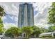Stunning high-rise building with a unique design surrounded by lush green trees on a partly cloudy day at 2870 Pharr Court S Nw # 1608, Atlanta, GA 30305
