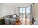 Bright living room with hardwood floors, neutral gray sofa, and large windows with cityscape view at 2870 Pharr Court S Nw # 1608, Atlanta, GA 30305