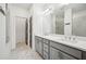 Bathroom featuring double sinks, quartz countertops, large mirror, and walk-in shower at 3130 Bennett Creek Ln, Suwanee, GA 30024