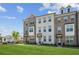 Beautiful townhouse complex showcasing brick and white exteriors, manicured lawn, and clear blue sky at 3130 Bennett Creek Ln, Suwanee, GA 30024