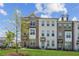Charming townhome exterior with brick and white facade, complemented by a lush green lawn and tree at 3130 Bennett Creek Ln, Suwanee, GA 30024