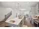 Open kitchen with stainless steel appliances, island, and stairway access at 3130 Bennett Creek Ln, Suwanee, GA 30024