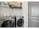 Laundry room equipped with front-load washer and dryer and ample shelf space at 3130 Bennett Creek Ln, Suwanee, GA 30024