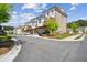 Street view of modern townhomes featuring attached garages and a beautiful landscaped entrance at 3130 Bennett Creek Ln, Suwanee, GA 30024