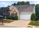 Attractive house boasting brick details, a white garage door, green hedges and a well-kept lawn at 3911 Delfaire Trce, Cumming, GA 30040