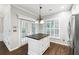 Bright kitchen island boasts granite counters, pendant lighting, and wood floors at 3911 Delfaire Trce, Cumming, GA 30040