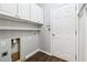 Functional laundry area features overhead cabinets, hookups, a wooden floor and access to an exterior door at 3911 Delfaire Trce, Cumming, GA 30040