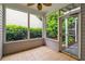Enclosed porch with tile flooring surrounded by lush greenery offers a relaxing outdoor space at 3911 Delfaire Trce, Cumming, GA 30040