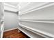 Walk-in closet with custom shelving, hardwood floors, and ample storage space at 3911 Delfaire Trce, Cumming, GA 30040