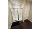 Bathroom featuring a shower with glass doors, white subway tile, and dark wood look flooring at 6905 Rogers Pt, Lithonia, GA 30058