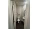 Small bathroom features a toilet, and a pedestal sink with a round mirror at 6905 Rogers Pt, Lithonia, GA 30058