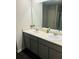 Bright bathroom featuring double sinks, large mirror, neutral countertop and grey cabinets at 6905 Rogers Pt, Lithonia, GA 30058