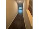 Inviting hallway with dark hardwood floors leading to a brightly lit room with staircase at 6905 Rogers Pt, Lithonia, GA 30058