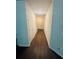 View of a home hallway with hardwood floors and neutral colored walls leading to the front door at 6905 Rogers Pt, Lithonia, GA 30058