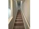 Carpeted staircase with white handrail ascending to the next level at 6905 Rogers Pt, Lithonia, GA 30058