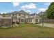 Expansive backyard features a patio, sunroom, grass, and a basketball court, perfect for outdoor living and recreation at 92 Creek Front Way, Lawrenceville, GA 30043