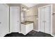 Bathroom with a single sink vanity and tile flooring with two doors at 92 Creek Front Way, Lawrenceville, GA 30043
