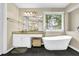 Bathroom with granite counters, tile floors, soaking tub and view of yard from the window at 92 Creek Front Way, Lawrenceville, GA 30043
