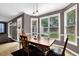 Bright dining room featuring natural light, a wooden table, and views of the landscaped backyard at 92 Creek Front Way, Lawrenceville, GA 30043