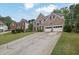 Attractive brick home showcasing a well-manicured lawn, a two-car garage and a long driveway at 92 Creek Front Way, Lawrenceville, GA 30043