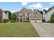 Attractive brick home showcasing a well-manicured lawn, a two-car garage and a long driveway at 92 Creek Front Way, Lawrenceville, GA 30043