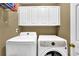Functional laundry room with washer, dryer, and built-in storage cabinets at 92 Creek Front Way, Lawrenceville, GA 30043
