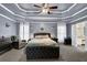 Spacious main bedroom with tray ceilings, plush carpeting, and an adjoining ensuite bathroom at 92 Creek Front Way, Lawrenceville, GA 30043